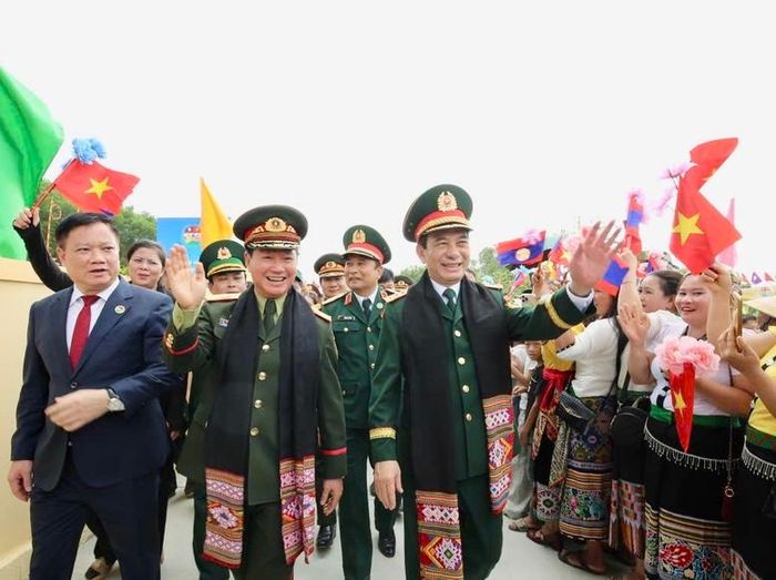Đông đảo nhân dân địa phương cầm cờ, hoa vẫy chào, cùng hô vang khẩu hiệu "Việt - Lào đoàn kết, đoàn kết; Việt - Lào samakkhi, samakkhi" - Ảnh: VGP/DA