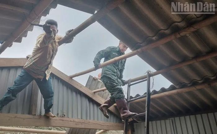 Cán bộ, chiến sĩ Đồn Biên phòng Chiềng Tương giúp gia đình ông Giàng Lao Cơ tháo dỡ nhà di dời khỏi nơi nguy hiểm.