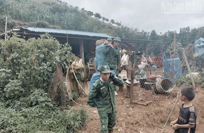 Cán bộ, chiến sĩ Đồn Biên phòng Chiềng Tương giúp gia đình ông Giàng Lao La di chuyển tài sản khỏi nơi nguy hiểm.