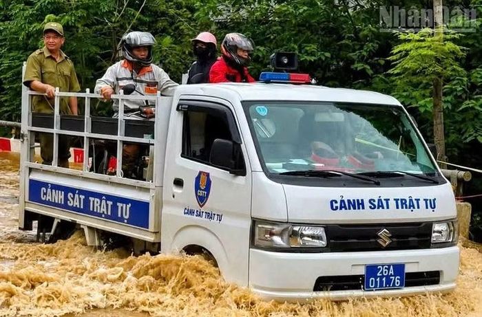 Công an xã Quỳnh Nhai, tỉnh Sơn La hỗ trợ nhân dân di chuyển qua một số điểm ngập sâu.