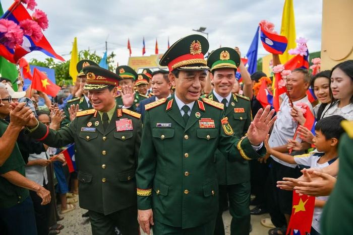 Bà con nhân dân biên giới chào mừng hai Phó Thủ tướng, Bộ trưởng Quốc phòng Việt Nam-Lào đến dự lễ sơ kết kết nghĩa cụm dân cư hai bên biên giới.