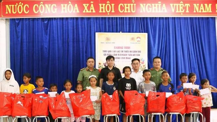 Các thành viên trong đoàn trao tặng học bổng và quà cho các em thiếu nhi có hoàn cảnh khó khăn.