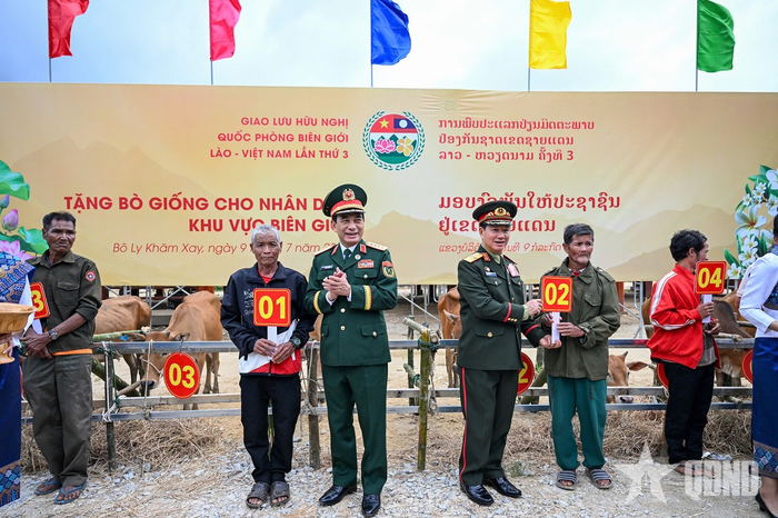 Đại tướng Phan Văn Giang và Đại tướng Khamliang Outhakaysone trao bò giống tặng các hộ dân của Lào ở khu vực biên giới. Ảnh: VIỆT TRUNG 