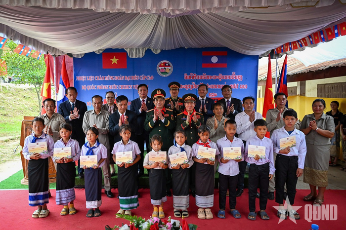 Đại tướng Phan Văn Giang và Đại tướng Khamliang Outhakaysone trao học bổng tặng các em học sinh có hoàn cảnh khó khăn tại Trường Tiểu học Thongnammoun. Ảnh: VIỆT TRUNG 