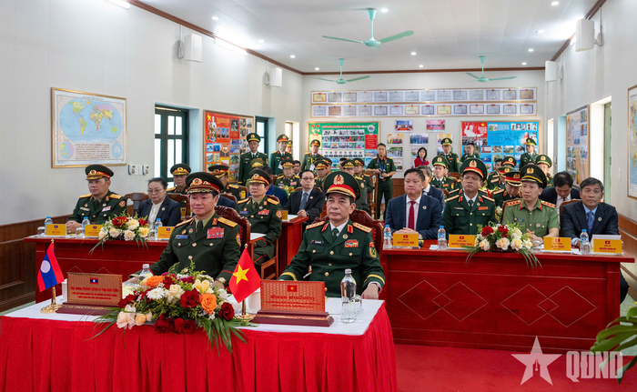 Hai đồng chí Phó thủ tướng, Bộ trưởng Bộ Quốc phòng Việt Nam - Lào và các đại biểu nghe báo cáo kết quả công tác của đơn vị.