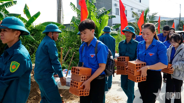 Lực lượng dân quân và đoàn viên thanh niên đóng góp ngày công xây dựng.