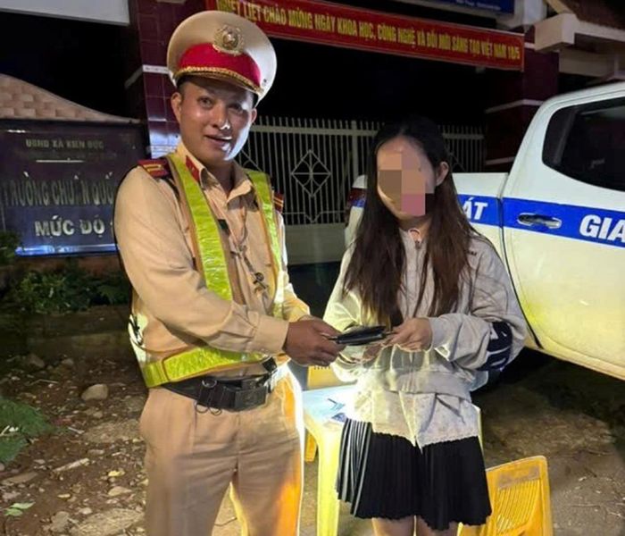 Cán bộ Đội CSGT đường bộ số 5 trao trả chiếc ví cho chị H.