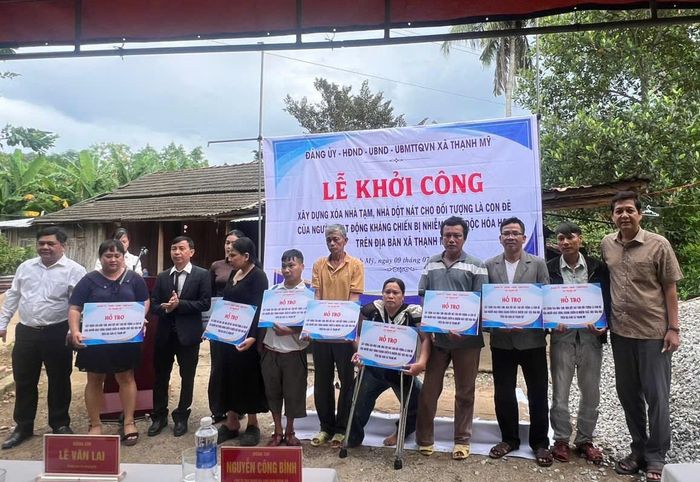Lãnh đạo xã Thạnh Mỹ trao biển tượng trưng hỗ trợ kinh phí cho các hộ gia đình.