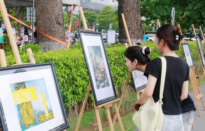 Bạn trẻ tham quan các tác phẩm hội họa, nhiếp ảnh trưng bày trong không gian mở bên bờ sông Hàn