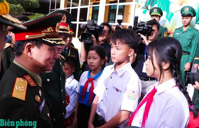 Đại tướng Phan Văn Giang và Đại tướng Khăm Liêng - Ụ Thạ Cay Sỏn động viên 4 cháu học sinh trong chương trình "Nâng bước em tới trường-Con nuôi đồn Biên phòng" do Đồn Biên phòng cửa khẩu Thanh Thủy, Bộ đội Biên phòng tỉnh Nghệ An đỡ đầu (trong đó có 1 cháu học sinh của nước bạn Lào). Ảnh: Chiến Khu