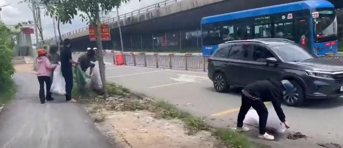 Hình ảnh những người vi phạm đi dọn rác, khắc phục hậu quả.