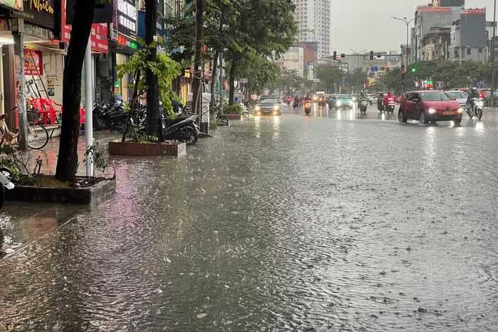 Một phần phố Tây Sơn bị ngập sau trận mưa lớn. Nước đọng trên mặt đường khiến các phương tiện phải giảm tốc khi lưu thông qua khu vực.