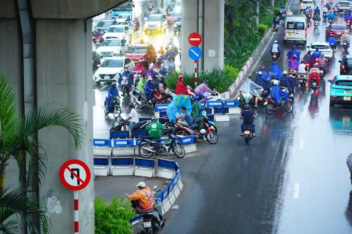  Một số người điều khiển xe máy dừng dưới gầm đường sắt trên cao để tránh mưa, chờ thời tiết ổn định rồi tiếp tục hành trình. 