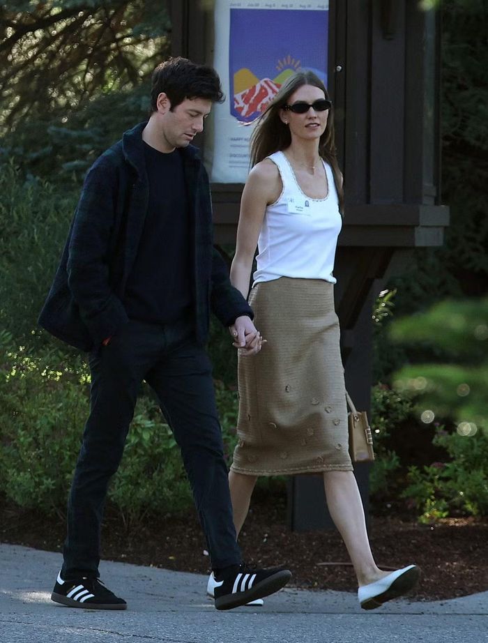 Tỷ phú Joshua Kushner và vợ - người mẫu Karlie Kloss dự hội nghị với phong cách tối giản. Karlie Kloss diện áo ba lỗ trắng phối chân váy len midi màu be, kết hợp giày bệt và túi xách da cỡ nhỏ. Người mẫu thường xuyên xuống phố với trang phục tông màu trung tính và phụ kiện tiết chế.