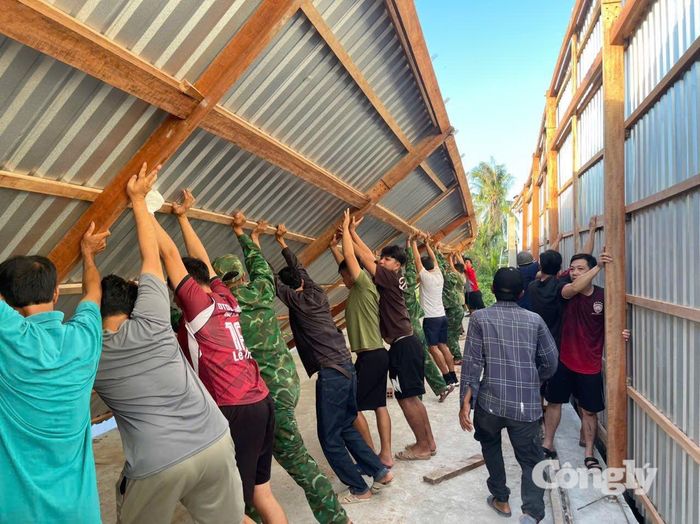 Cán bộ, chiến sĩ Đồn Biên phòng Đất Mũi cùng người dân dựng lại nhà cho chị Quỳnh ổn định cuộc sống.