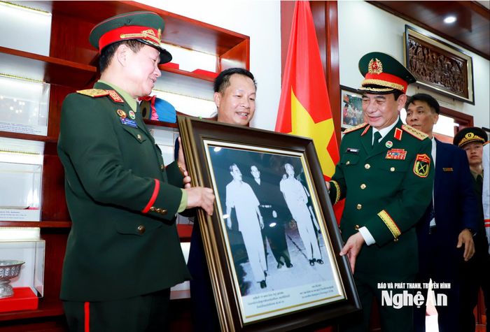 Đại tướng Phan Văn Giang - Ủy viên Bộ Chính trị, Phó Thủ tướng Chính phủ, Bộ trưởng Bộ Quốc phòng Việt Nam và Đại tướng Khamliang Outhakaysone - Ủy viên Bộ Chính trị Đảng Nhân dân Cách mạng Lào, Phó Thủ tướng Chính phủ, Bộ trưởng Bộ Quốc phòng Lào tặng quà lưu niệm đến Ban Quản lý Khu Di tích Quốc gia đặc biệt Kim Liên. Ảnh: Thành Duy