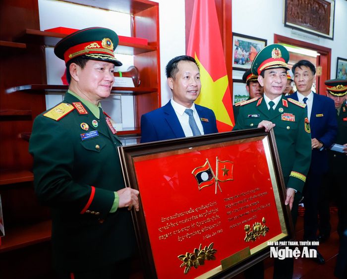 Đại tướng Phan Văn Giang - Ủy viên Bộ Chính trị, Phó Thủ tướng Chính phủ, Bộ trưởng Bộ Quốc phòng Việt Nam và Đại tướng Khamliang Outhakaysone - Ủy viên Bộ Chính trị Đảng Nhân dân Cách mạng Lào, Phó Thủ tướng Chính phủ, Bộ trưởng Bộ Quốc phòng Lào tặng quà lưu niệm đến Ban Quản lý Khu Di tích Quốc gia đặc biệt Kim Liên. Ảnh: Thành Duy