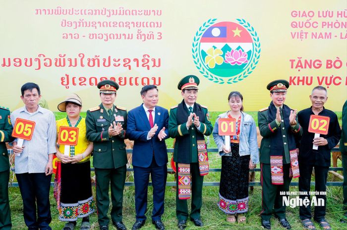 Đại tướng Phan Văn Giang và Đại tướng Khamliang Outhakaysone cùng các đại biểu tặng quà cho các hộ gia đình có hoàn cảnh khó khăn ở khu vực biên giới các xã Kim Bảng và xã Sơn Lâm. Ảnh: Phạm Bằng