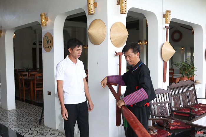 Ông Dương Văn Đức - chủ mô hình CBT biển Thịnh Lộc giới thiệu với anh Tráng A Chu về ý nghĩa của những trang trí nội thất mang đậm văn hóa làng biển tại mô hình.