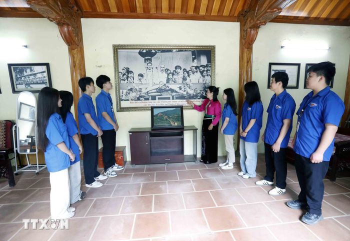Đoàn viên thanh niên xem bức ảnh Bác Hồ và Đoàn công tác của Trung ương trong chuyến thăm, nói chuyện với đồng bào các dân tộc Tây Bắc ở Di tích lịch sử Quốc gia Kỳ đài Thuận Châu. (Ảnh: Quang Quyết/TTXVN)