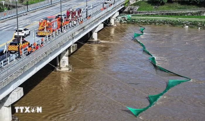 Lực lượng cứu hộ giăng lưới để tìm kiếm người đàn ông bị nước lũ cuốn trôi tại suối Namwon, tỉnh Gyeongsang Bắc, Hàn Quốc ngày 9/7/2026. (Ảnh: Yonhap/TTXVN phát)