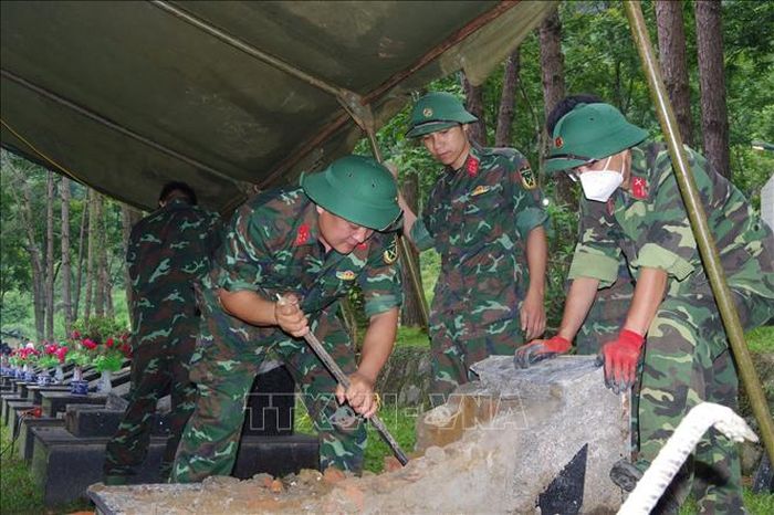 Lực lượng chức năng tiến hành khai quật hài cốt liệt sĩ.