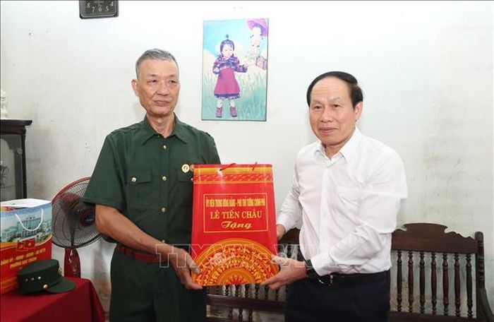 Phó Thủ tướng Chính phủ Lê Tiến Châu tặng quà cho thương binh Đào Đình Hảo. Ảnh: TTXVN phát