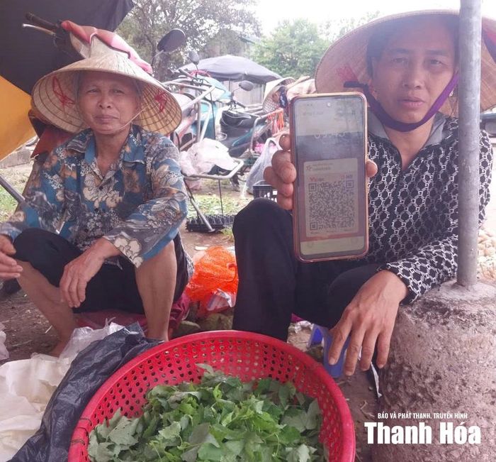 Bà Lan, người bán hàng rau củ ở chợ Voi đã lưu mã QR trong điện thoại để tiện giao dịch với khách.