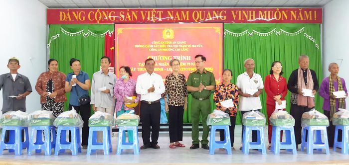 Các đơn vị phối hợp trao quà cho người dân.