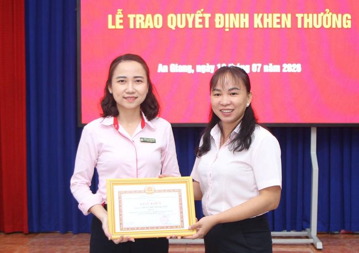 Bí thư Đảng ủy, Chủ tịch Công ty TNHH MTV Xổ số Kiến thiết An Giang Phan Thị Kim Hai trao giấy khen cho đảng viên Trần Thị Tố Quyên.