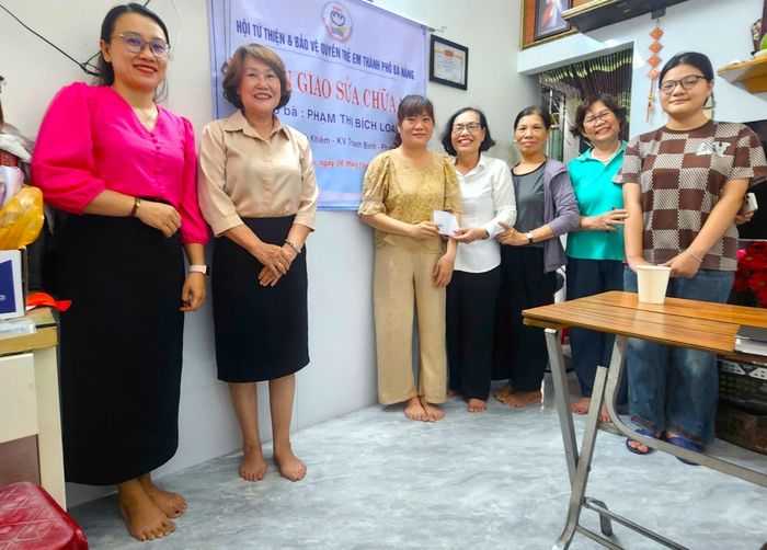 Hội Từ thiện và Bảo vệ quyền trẻ em thành phố hỗ trợ kinh phí sửa chữa nhà cho chị Phạm Thị Bích Loan (thứ 3, bên trái sang). Ảnh: PHƯỚC AN