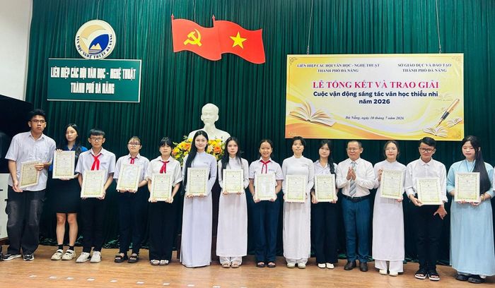 Ông Phan Chín, Phó Chủ tịch Liên hiệp các Hội Văn học - Nghệ thuật thành phố Đà Nẵng trao giải cho các học sinh. Ảnh: KHÁNH HUYỀN