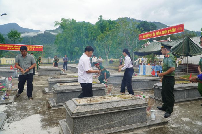 Cán bộ và nhân dân xã Nam Trà My dâng hương tại nghĩa trang trước khi lấy mẫu sinh phẩm. Ảnh: TRUNG LÊ