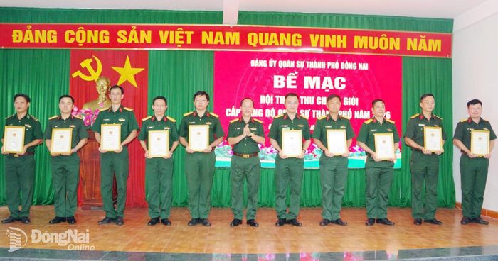 Đại tá Bùi Khánh Hòa, Phó Chỉ huy trưởng Bộ Chỉ huy Quân sự thành phố trao quyết định công nhận các đồng chí đạt danh hiệu Bí thư Chi bộ giỏi. Ảnh: Anh Tuấn