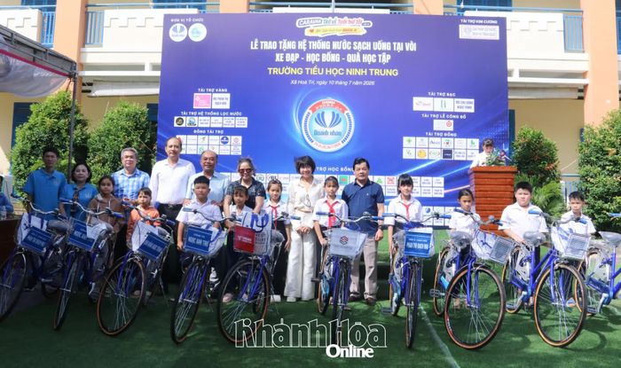 Lãnh đạo xã Hòa Trí và các nhà tài trợ trao xe đạp cho học sinh.