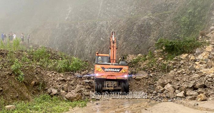 Lực lượng chức năng huy động máy móc khẩn trương hót dọn đất, đá tại điểm sạt lở Km156+300, quốc lộ 279.