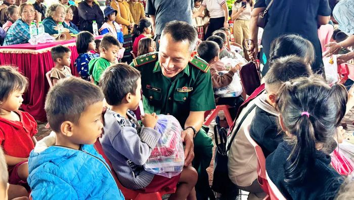 Cán bộ Đồn Biên phòng Ba Tầng trao quà cho các cháu học sinh - Ảnh: N.M