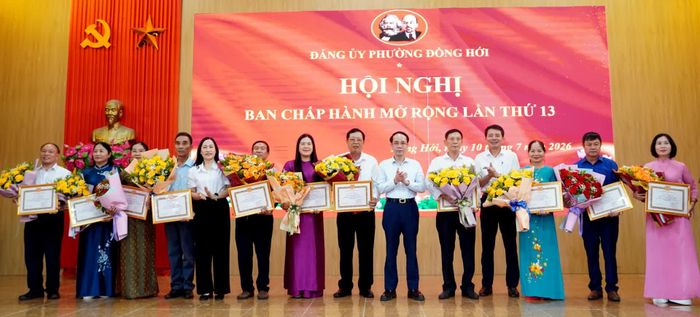 Đồng chí Phan Mạnh Hùng, Bí thư Đảng ủy phường Đồng Hới và các đồng chí trong Thường trực Đảng ủy phường trao giấy khen tặng các đảng viên - Ảnh: H.Tr