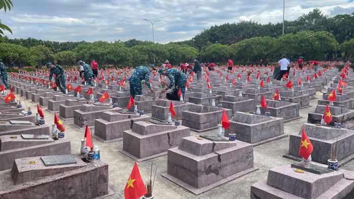 Các đoàn viên, thanh niên chăm sóc khuôn viên Nghĩa trang liệt sĩ Ba Dốc - Ảnh: L.T