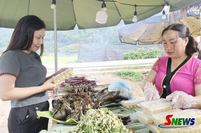 Du khách tìm hiểu về các món ăn địa phương tại chợ phiên bản Vặt Hồng, phường Mộc Châu.