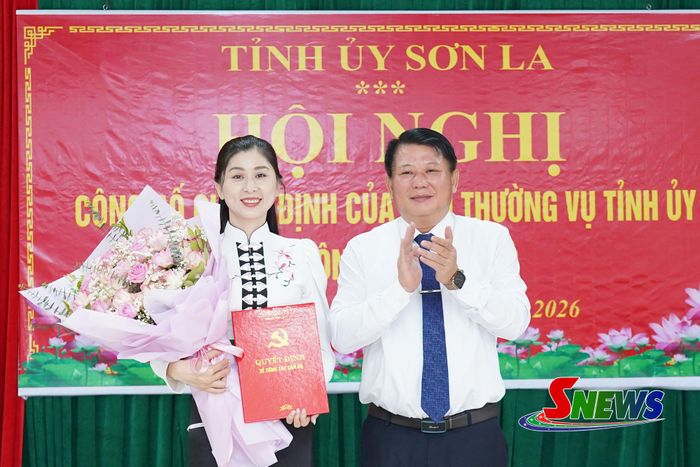 Đồng chí Lò Minh Hùng trao quyết định và tặng hoa chúc mừng đồng chí Cầm Thị Huyền Trang. 