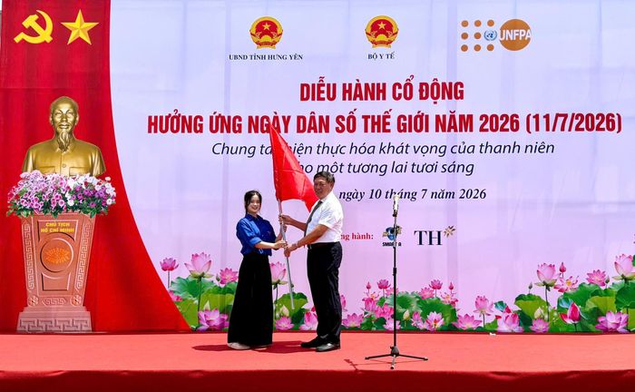 Lãnh đạo Bộ Y tế thực hiện nghi thức trao cờ phát động đoàn diễu hành hưởng ứng Ngày Dân số Thế giới năm 2026. Ảnh: Hải Yến