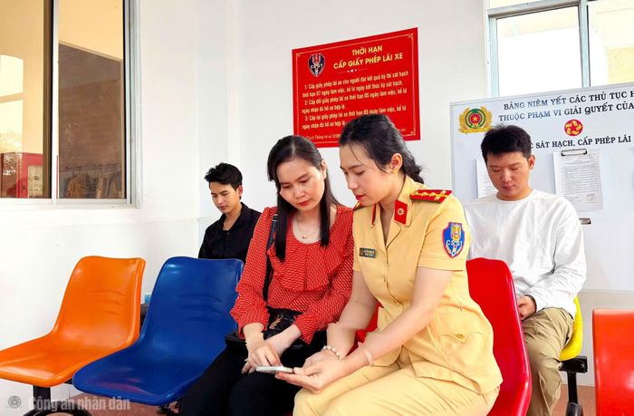 Cán bộ Phòng CSGT hướng dẫn người dân thực hiện tích hợp giấy phép lái xe vào ứng dụng VNeID và sử dụng ứng dụng VNeTraffic.