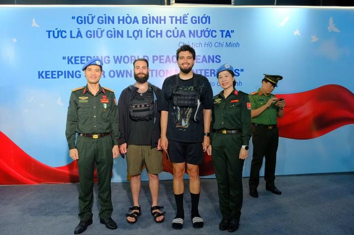 Các sĩ quan GGHB Bộ Công an chụp ảnh lưu niệm với du khách quốc tế.
