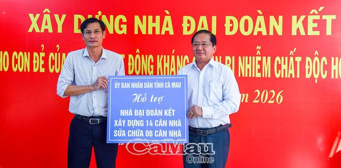 Đồng chí Lê Thanh Triều (bên phải), Ủy viên Ban Thường vụ Tỉnh ủy, Phó Chủ tịch Thường trực Ủy ban MTTQ Việt Nam tỉnh Cà Mau trao bảng tượng trưng hỗ trợ nhà Đại đoàn kết gồm xây dựng 14 căn nhà và sửa chữa 6 căn, cho xã Hưng Mỹ.