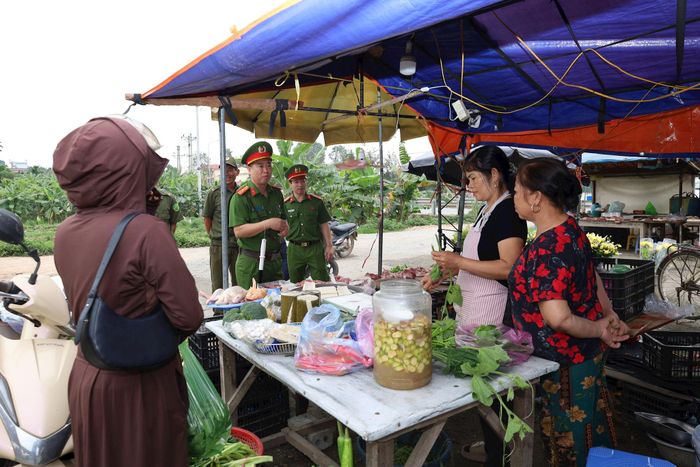 Lực lượng Công an xã Phúc Sơn tuyên truyền hộ kinh doanh tại các chợ biện pháp bảo đảm an toàn, vệ sinh thực phẩm, phòng chống cháy nổ. Ảnh: Kim Nhuệ