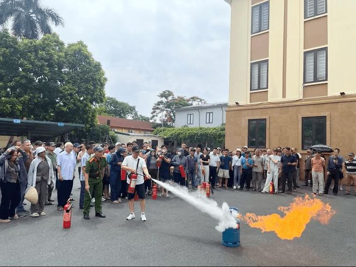 Người dân thực hành thao tác sử dụng bình chữa cháy xách tay để dập tắt đám cháy giả định. Ảnh CAHN