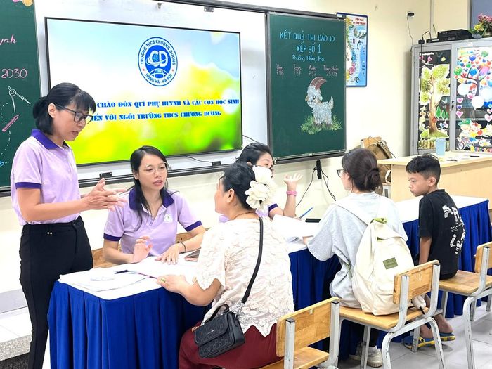Cán bộ, giáo viên Trường THCS Chương Dương hỗ trợ phụ huynh học sinh đăng ký tuyển sinh. Ảnh: Lê Nguyễn