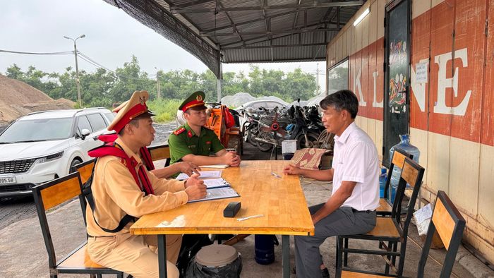Lực lượng chức năng làm việc với đại diện cơ sở kinh doanh vật liệu dọc sông Hồng. Ảnh: Vân Nhi