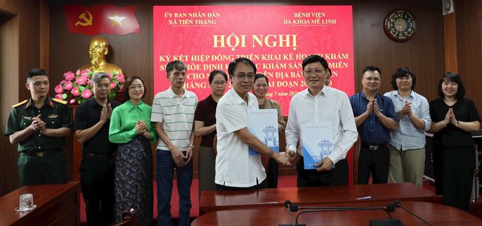 Các đồng chí lãnh đạo UBND xã Tiến Thắng và Bệnh viện Đa khoa Mê Linh cùng các đại biểu thực hiện ký kết Biên bản hiệp đồng giữa 2 đơn vị. Ảnh: PV